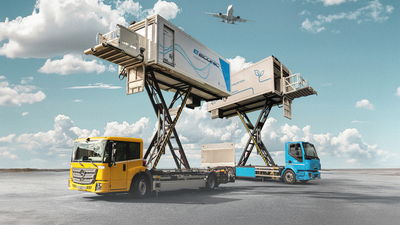 Electric catering trucks with elevated platforms servicing planes, featuring sustainable designs against a clear sky backdrop.